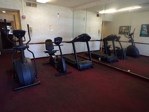 A gym with cardio equipment including treadmills and an elliptical. - Piccadilly Inn Airport (Fresno)