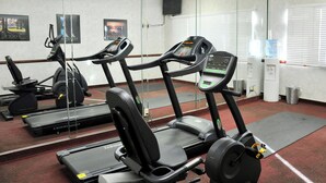 A gym with treadmills, a weight bench, and exercise equipment.