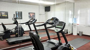 A gym with treadmills, weight machines, and a water dispenser.