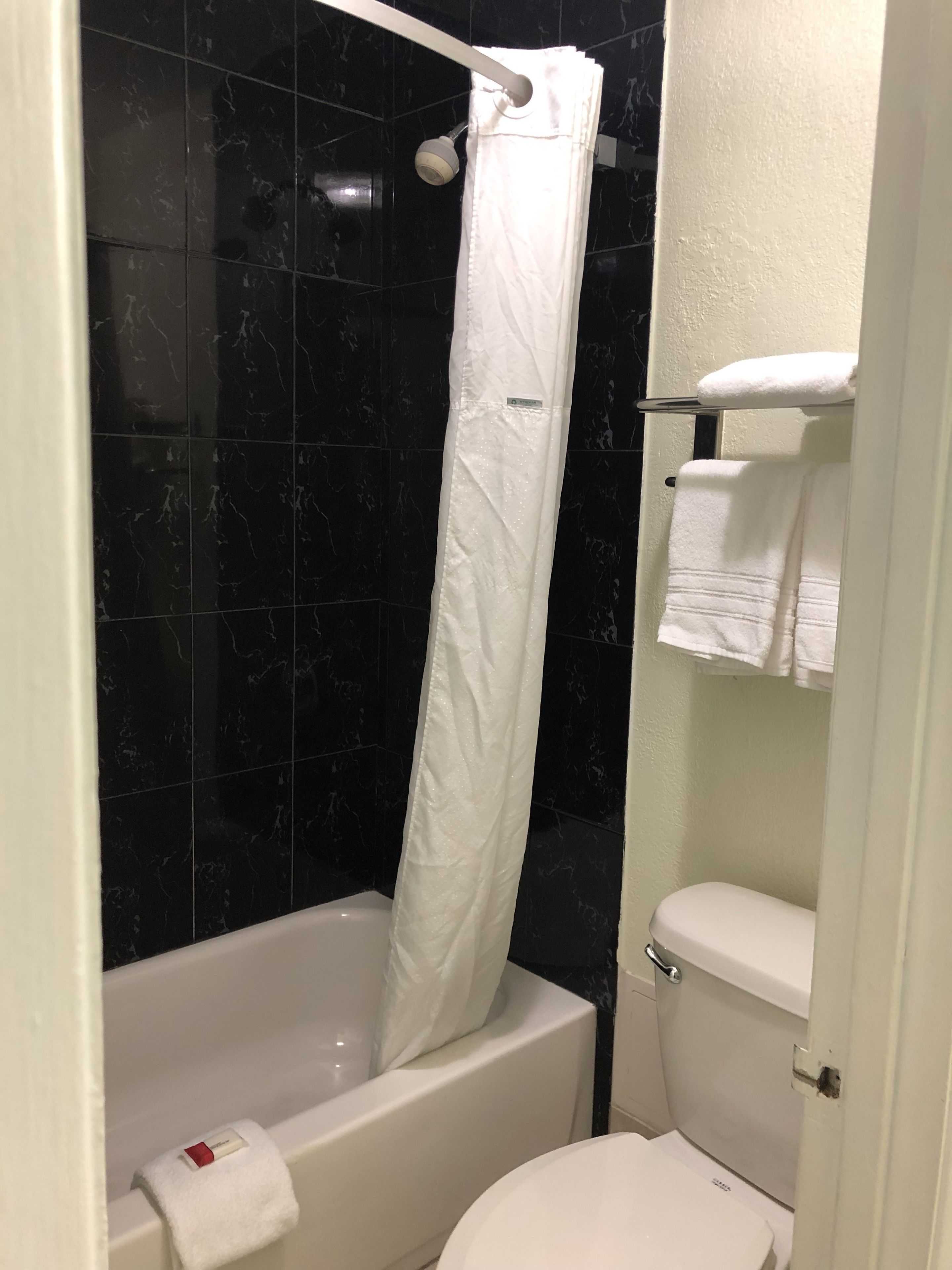 Ein Badezimmer mit Badewanne, Toilette und Duschvorhang.
