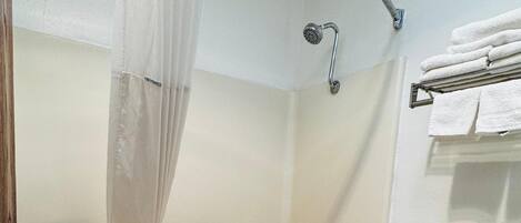 A bathroom with a bathtub, toilet, and shower curtain.