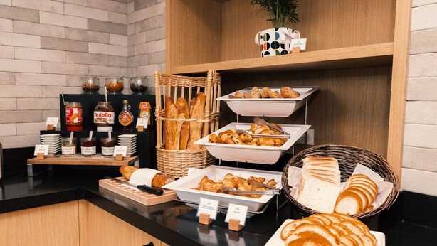 Buffet de l'esmorzar amb diferents pastissos, pa i condiments.