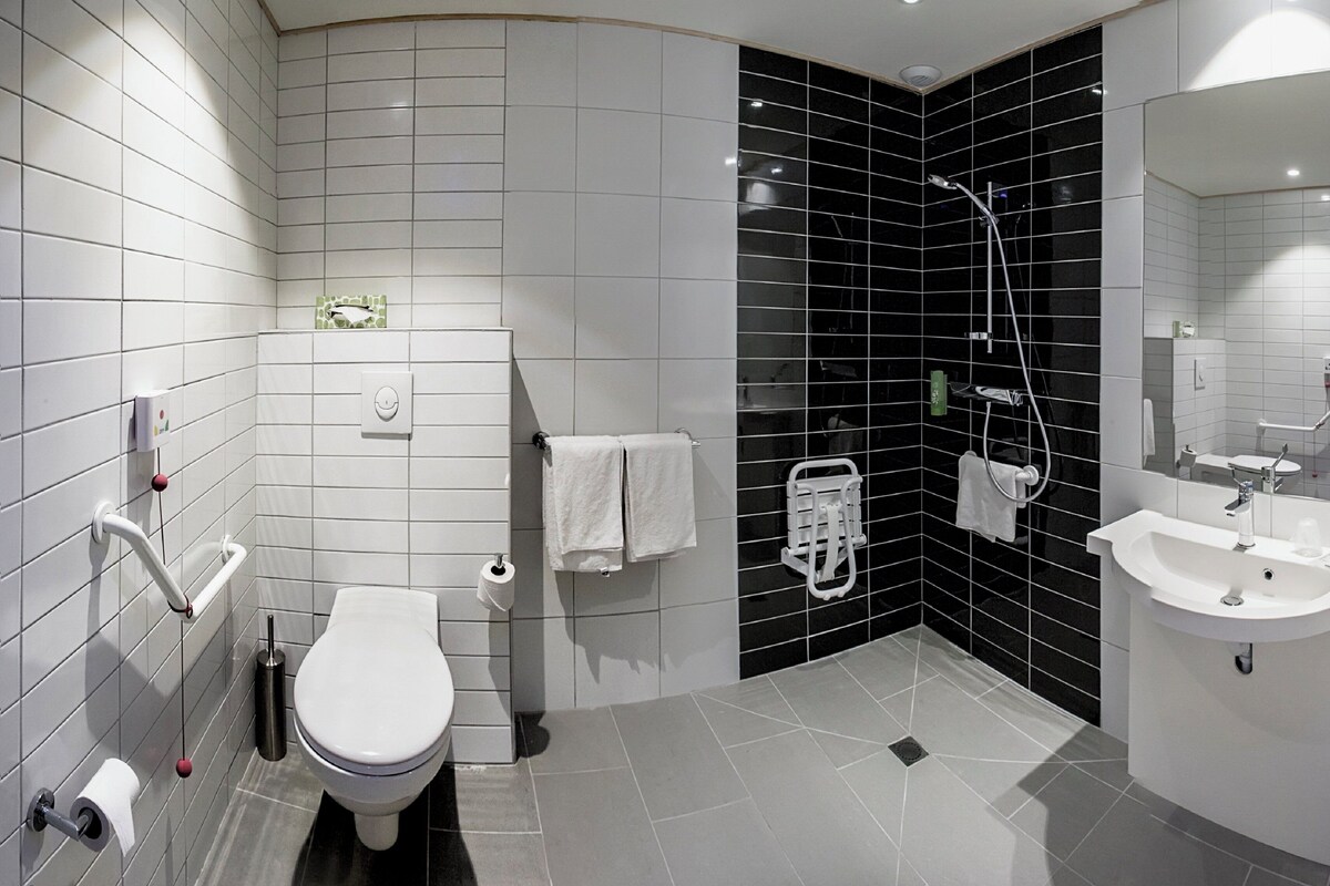 A modern bathroom with a toilet, sink, and shower.