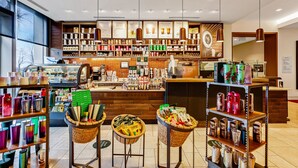 A coffee shop interior with shelves of coffee beans, a counter with a menu, and baskets of items on stools. - The Westin Pittsburgh, a Marriott Hotel (Pittsburgh)