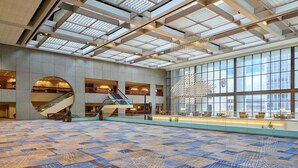 A spacious lobby with a patterned floor, large windows, and a modern ceiling design. - Sheraton Kansas City Hotel at Crown Center (Kansas City)