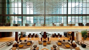 A spacious lobby with multiple seating areas, large windows, and a decorative ceiling. - Sheraton Kansas City Hotel at Crown Center (Kansas City)