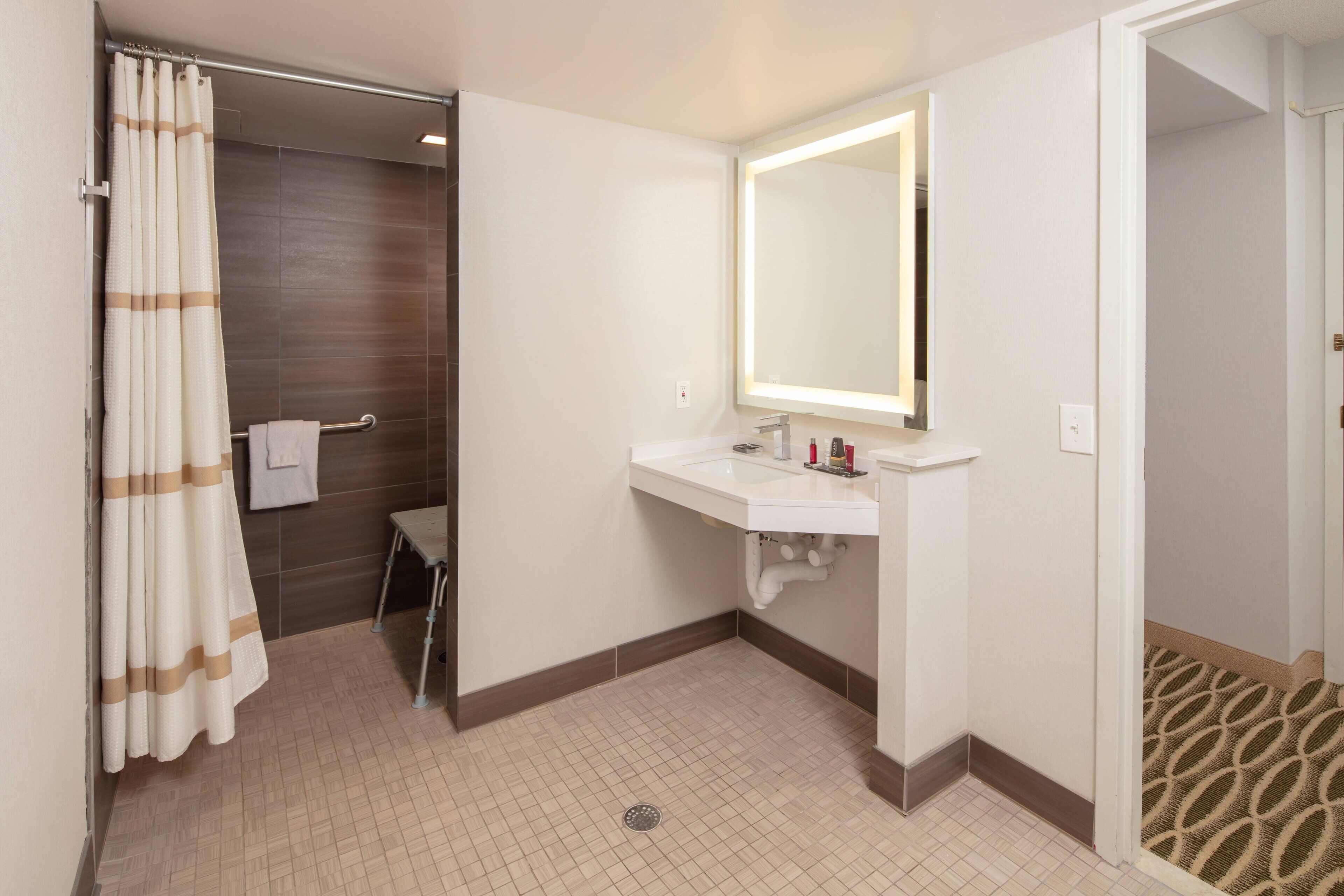 A bathroom with a white sink, mirror, and shower curtain.