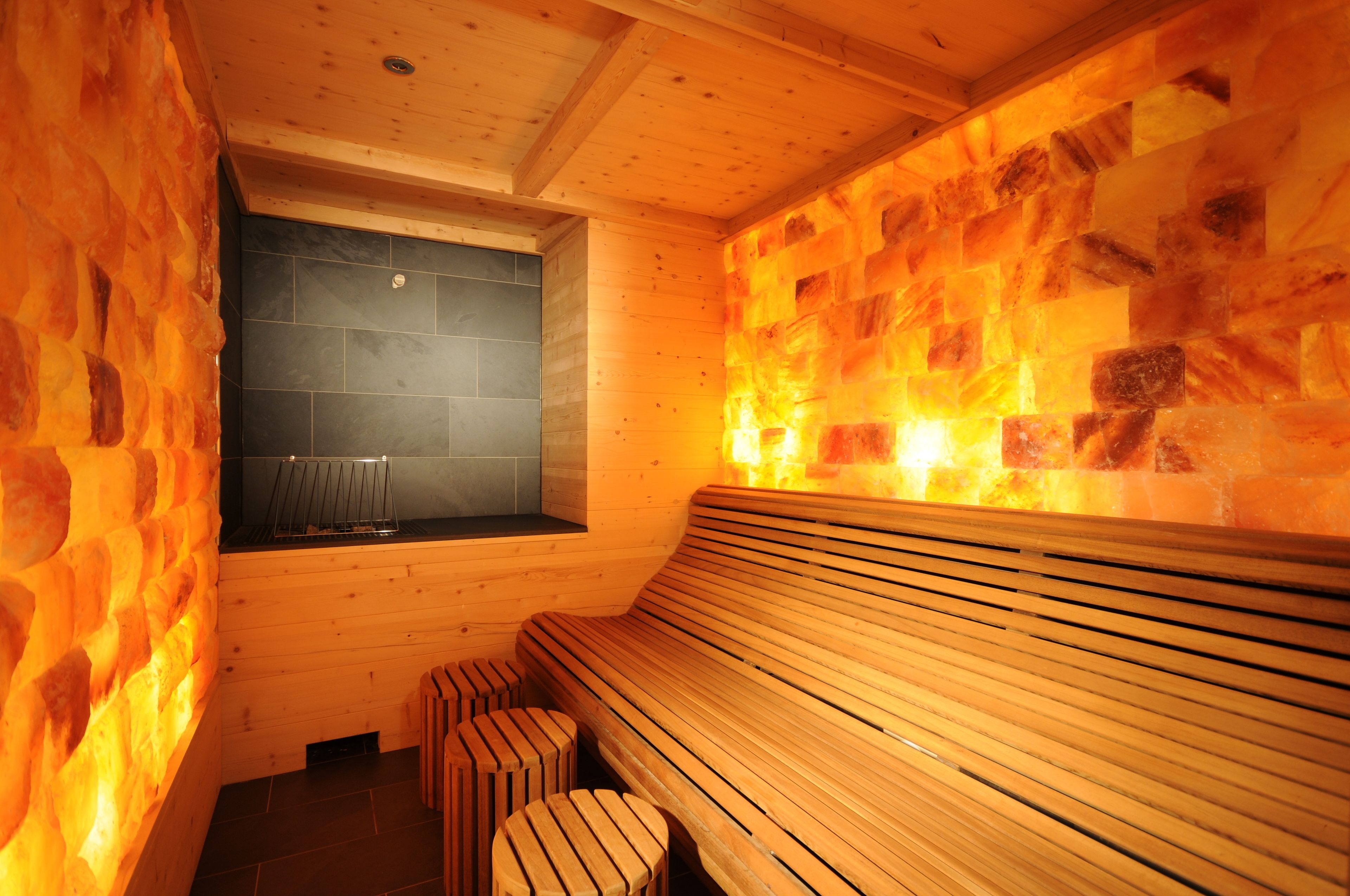 Eine Sauna mit Holzbänken und einer Steinwand.