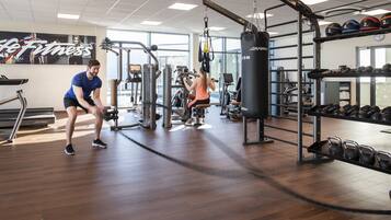 A gym with treadmills, weight machines, and a punching bag.