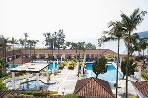 A resort with multiple swimming pools, covered areas, and lush landscaping.