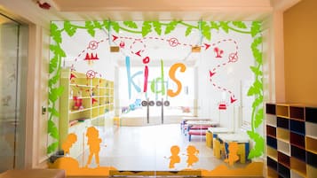 Welcome to the children's club, where kids can play and socialize in a vibrant space with various seating areas and storage units.
