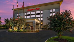 A Hampton Inn hotel with a modern facade, large windows, and a well-lit entrance. - Hampton Inn Oak Ridge Knoxville (Oak Ridge)
