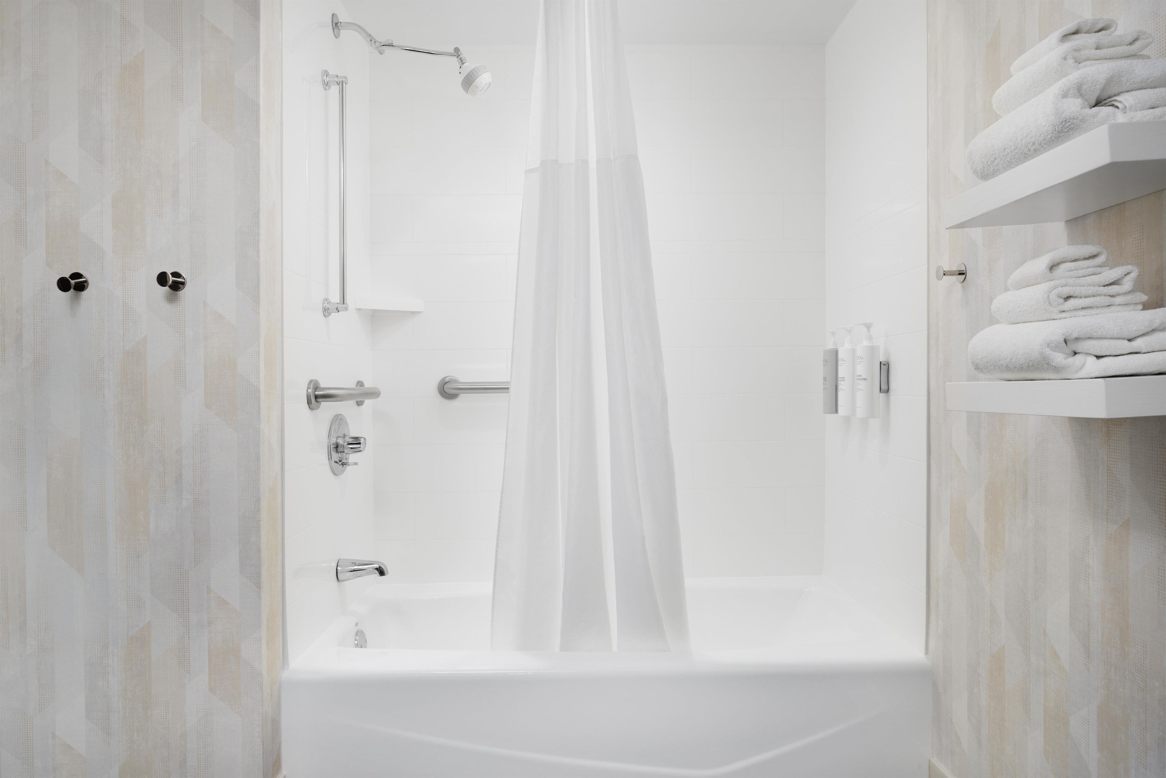 Ein modernes Badezimmer mit Badewanne, Dusche und Handtuchhalter.