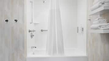Ein modernes Badezimmer mit Badewanne, Dusche und Handtuchhalter.