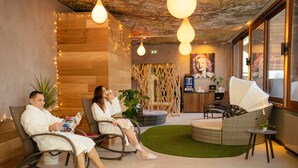 A modern indoor relaxation area with seating, a small table, and a decorative plant. - Domaine de la Forêt d’Orient, Logis Hôtel, Restaurant, Spa & Golf (Rouilly-Sacey)