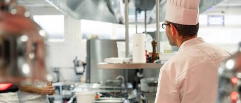A chef in a professional kitchen with stainless steel surfaces and modern equipment.