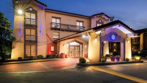 A hotel with a central entrance, a covered porch, and a balcony. - Days Inn by Wyndham Birmingham/West (Birmingham)