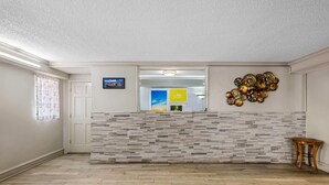 A reception area with a modern design, featuring a patterned wall and a wooden floor. - Days Inn by Wyndham Birmingham/West (Birmingham)