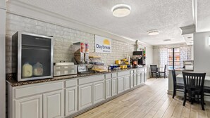 A breakfast bar with a refrigerator, milk cartons, and a coffee machine. - Days Inn by Wyndham Birmingham/West (Birmingham)