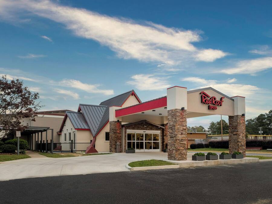 A Red Roof Inn with a modern architectural design, featuring a prominent entrance and a covered parking area.