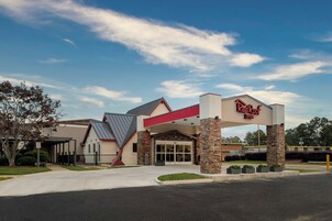A Red Roof Inn with a modern architectural design, featuring a prominent entrance and a covered parking area.