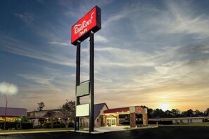 A Red Roof Inn with a prominent sign, a parking lot, and a building with a red roof and entrance. - Red Roof Inn Lumberton (Lumberton)
