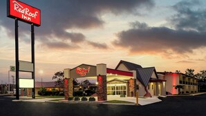 A RedRoof Inn with a large sign, a parking lot, and a building entrance. - Red Roof Inn Lumberton (Lumberton)