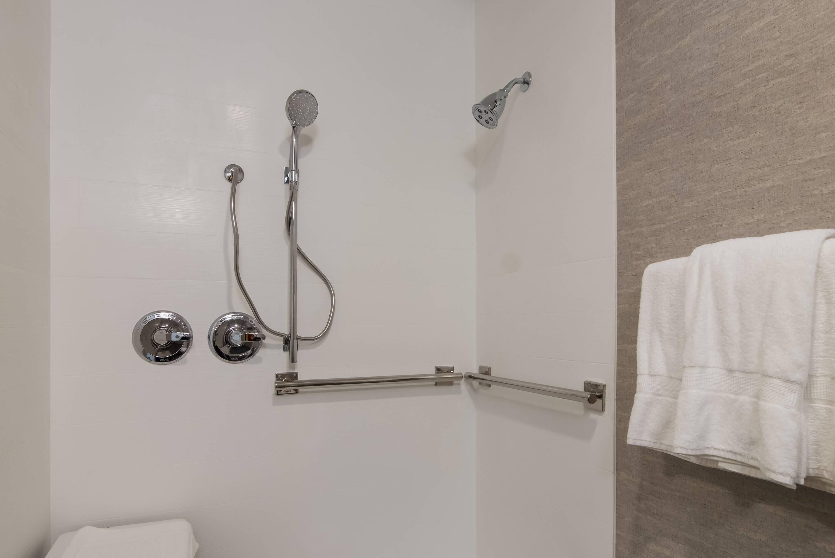 A bathroom with a shower, a towel rack, and a toilet.