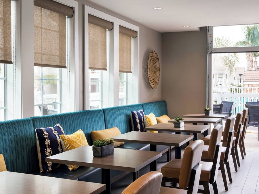 Un restaurant avec des banquettes de couleur turquoise, des tables et des chaises en bois.