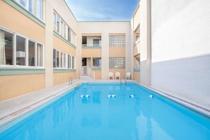 Piscine extérieure en saison, chaises longues