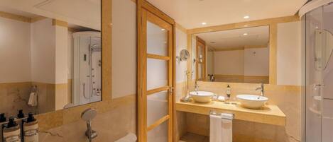 A modern bathroom with a bathtub, two sinks, a shower, and a glass-enclosed shower area.