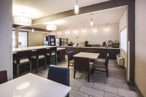 Eine moderne Hotelhalle mit Bar, Sitzgelegenheiten und einer Küchenzeile.