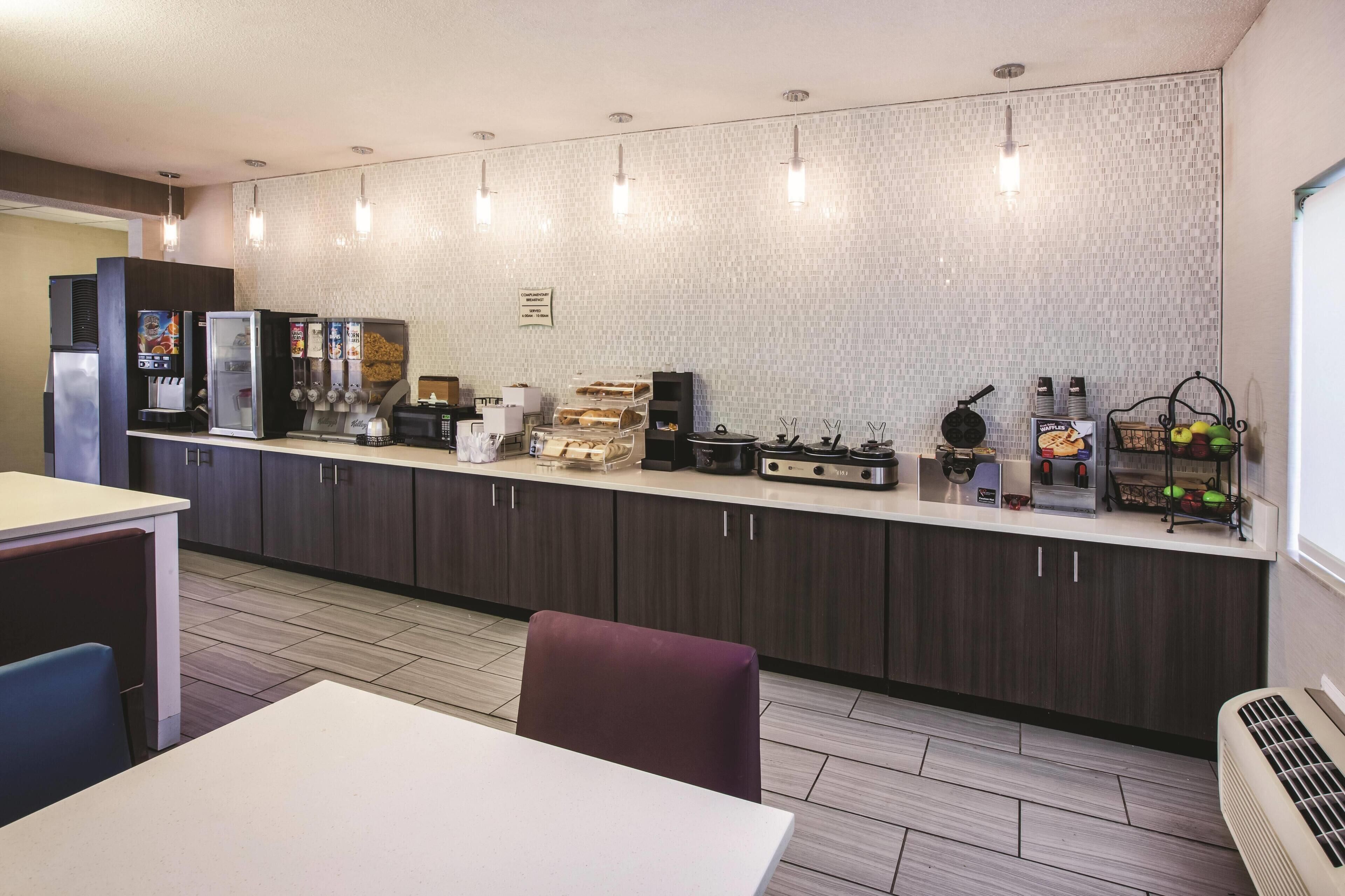 Une cuisine moderne équipée d’un bar pour prendre le petit-déjeuner, de machines à café et d’un appareil à gaufres.
