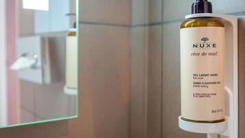 A hand cleansing gel dispenser mounted on a wall.