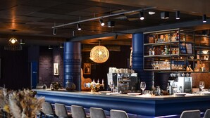 A bar area with a counter, bar stools, and a coffee machine. - Demeures de campagne Château de Fontainebleau – Mercure (Fontainebleau)