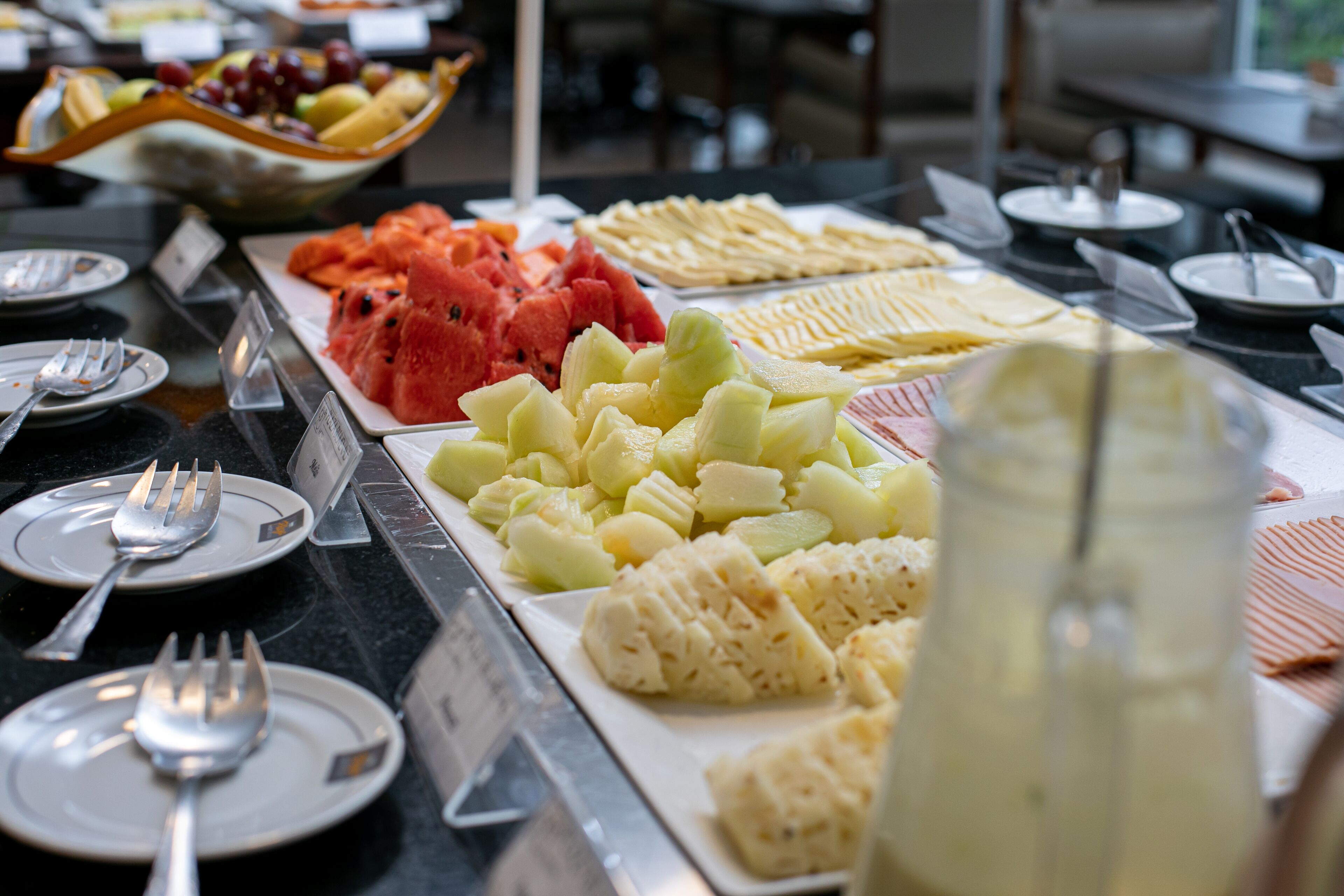 En buffet med et udvalg af frugter og en kande drikke.