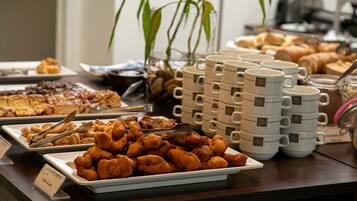 Un bufé con diversas opciones de comida, incluyendo pasteles y galletas.