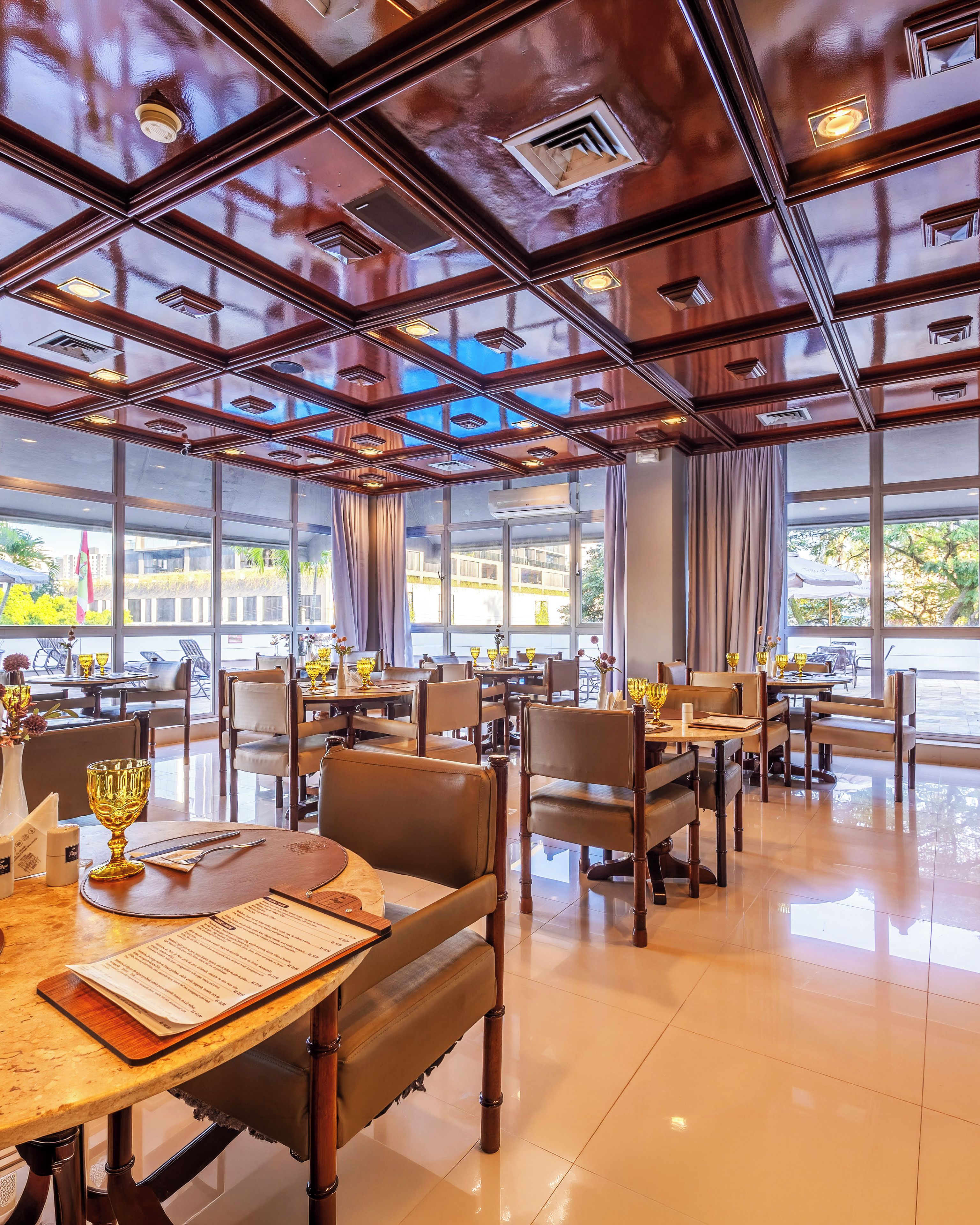 Un restaurant doté de nombreuses tables, de chaises et d’un plafond équipé d’un éclairage encastré.