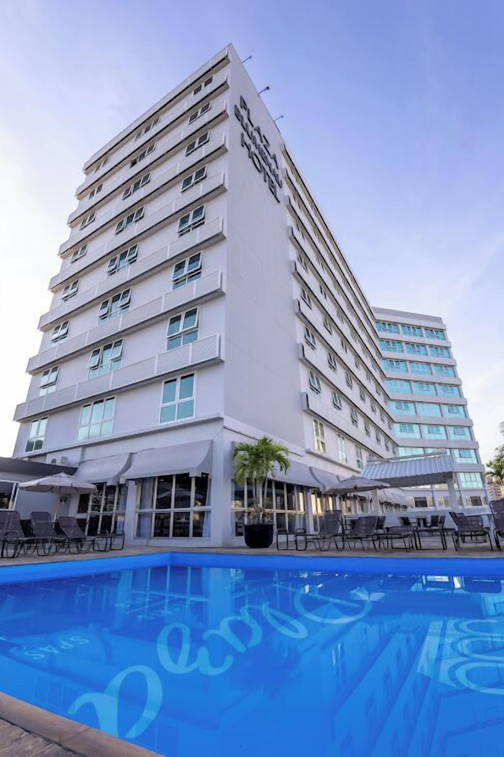 A multi-story hotel with a swimming pool in the foreground.