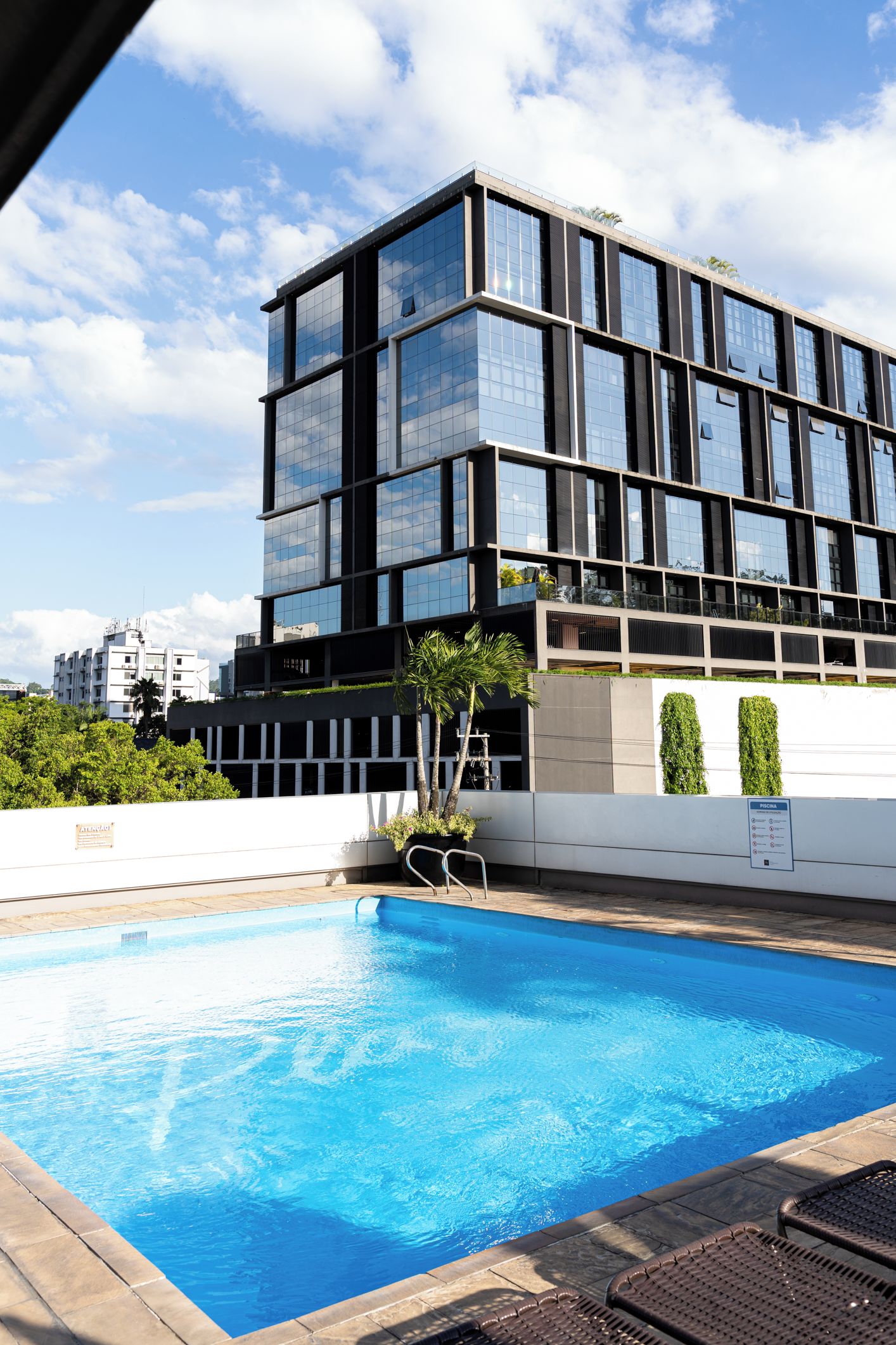 Um edifício moderno com piscina em frente.