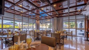 Un restaurante espacioso con techos altos, amplias ventanas y un diseño de interiores moderno.