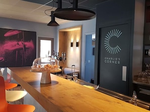 A bar area with a wooden counter, a glass display case, and a sign reading 'CHARLIE'S CORNER'. - ibis Melun Hotel (Melun)