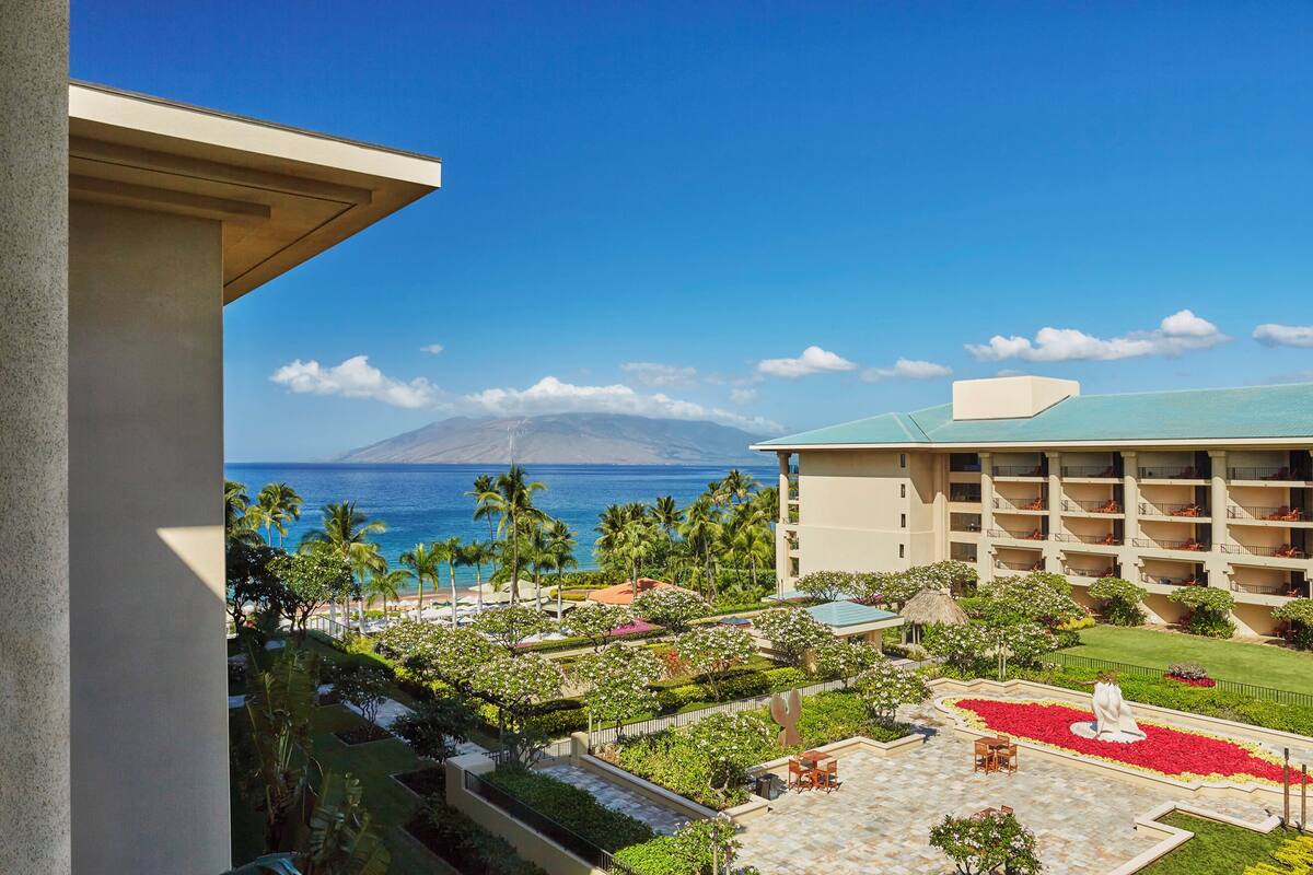 Un hôtel doté d’une piscine, d’un jardin et offrant une vue sur l’océan.