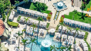 Vue aérienne d’un complexe hôtelier doté de plusieurs piscines, de palmiers et d’espaces de détente.