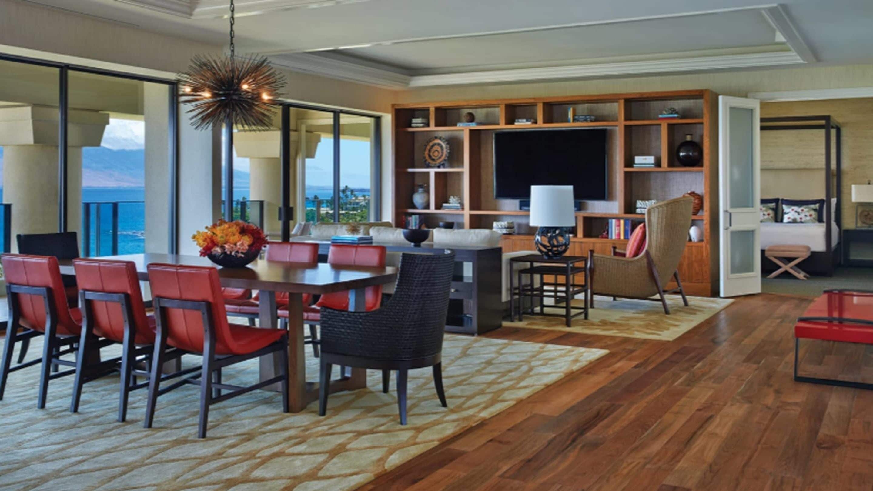 A spacious living room with a dining area, a television, and a bookshelf.