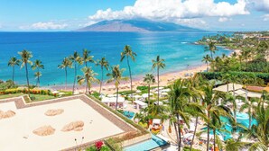 Un complexe hôtelier doté d’une piscine, d’une plage et offrant une vue sur les montagnes.