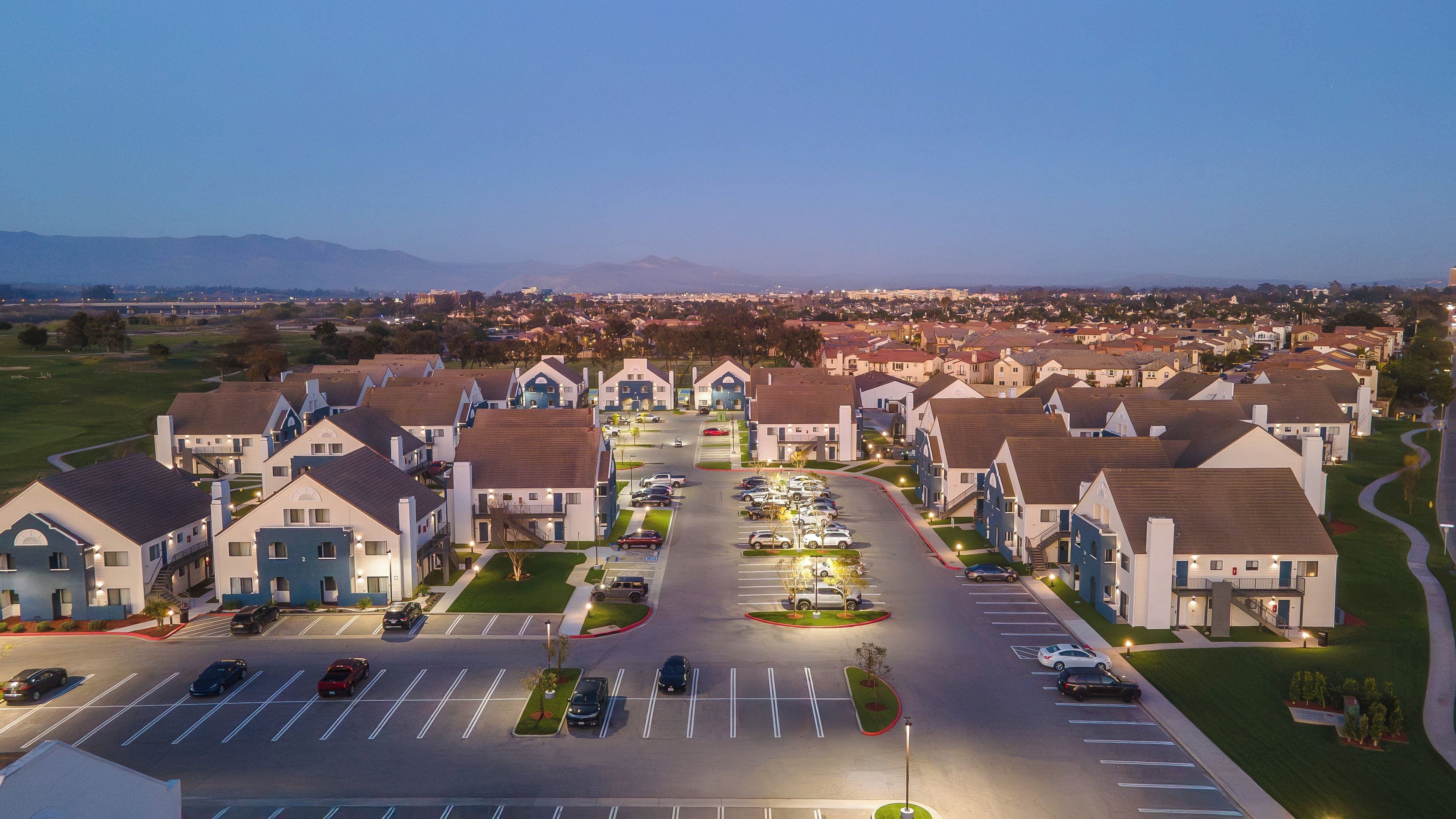 Zona residencial con casas modernas, un estacionamiento y una vista despejada del paisaje circundante.