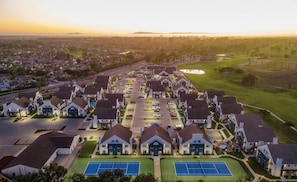 A residential area with houses, a tennis court, and a golf course.