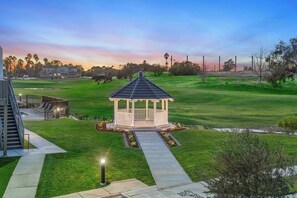 A gazebo in a well-maintained lawn with a pathway leading to it, surrounded by trees and a distant building. - Staybridge Suites Oxnard River Ridge by IHG (Oxnard)
