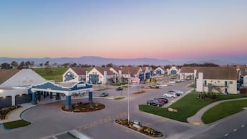 A Staybridge hotel with a central parking area, multiple buildings, and a flagpole with an American flag.